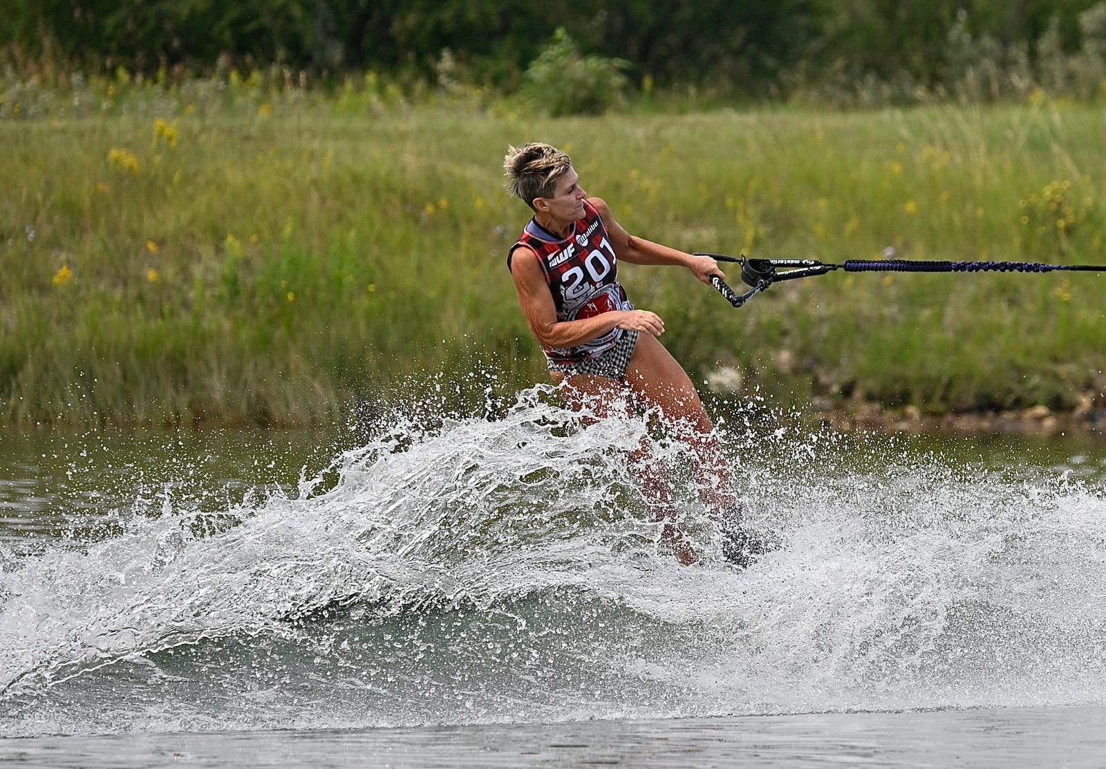 A skier carving a slalom turn with spray behind